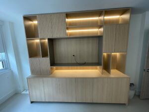 Modern wooden entertainment unit with integrated lighting and shelves.