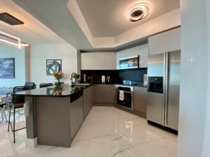 Modern kitchen with sleek appliances and glossy flooring.
